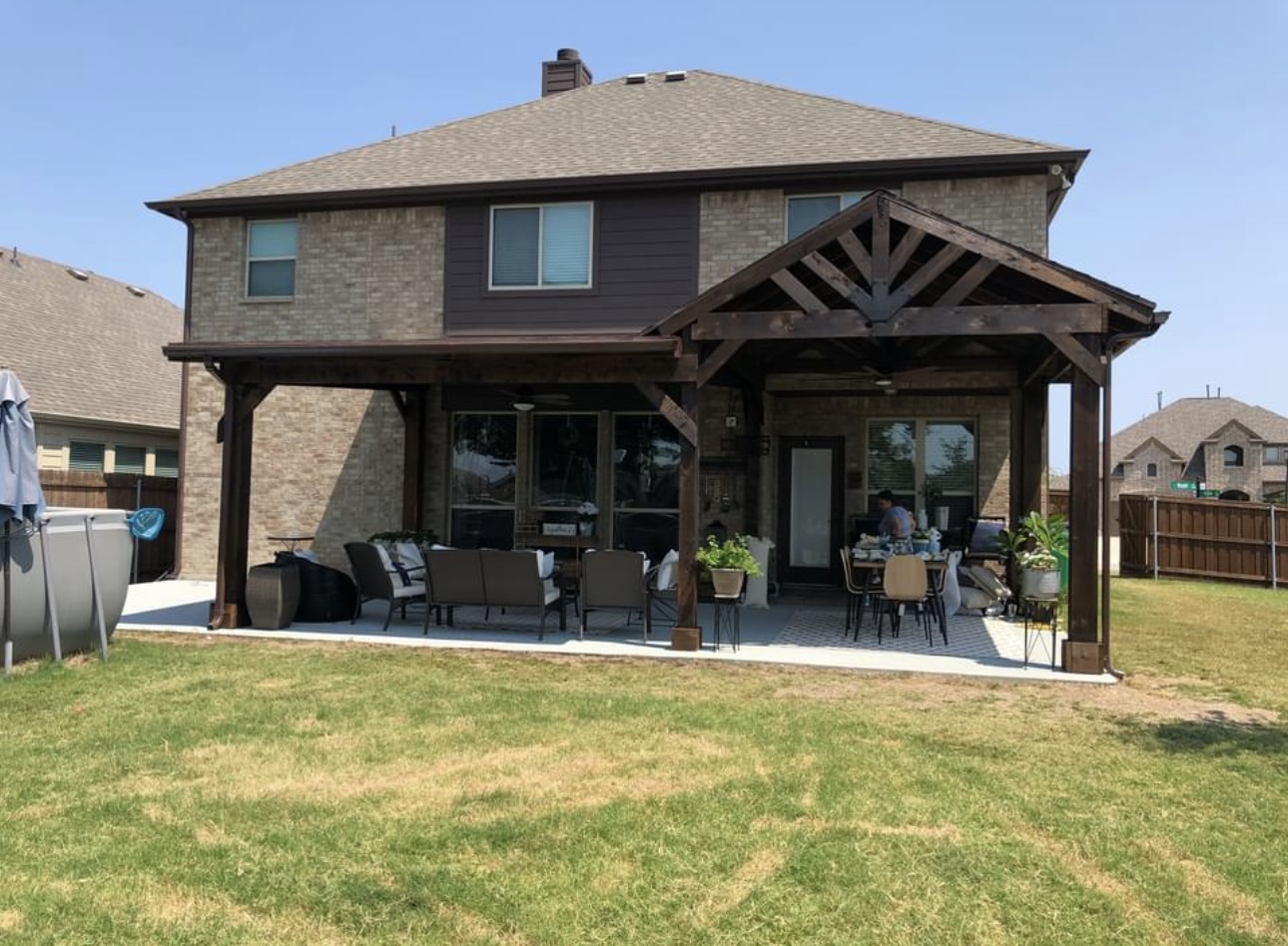 A patio cover attached to a two-story brick home